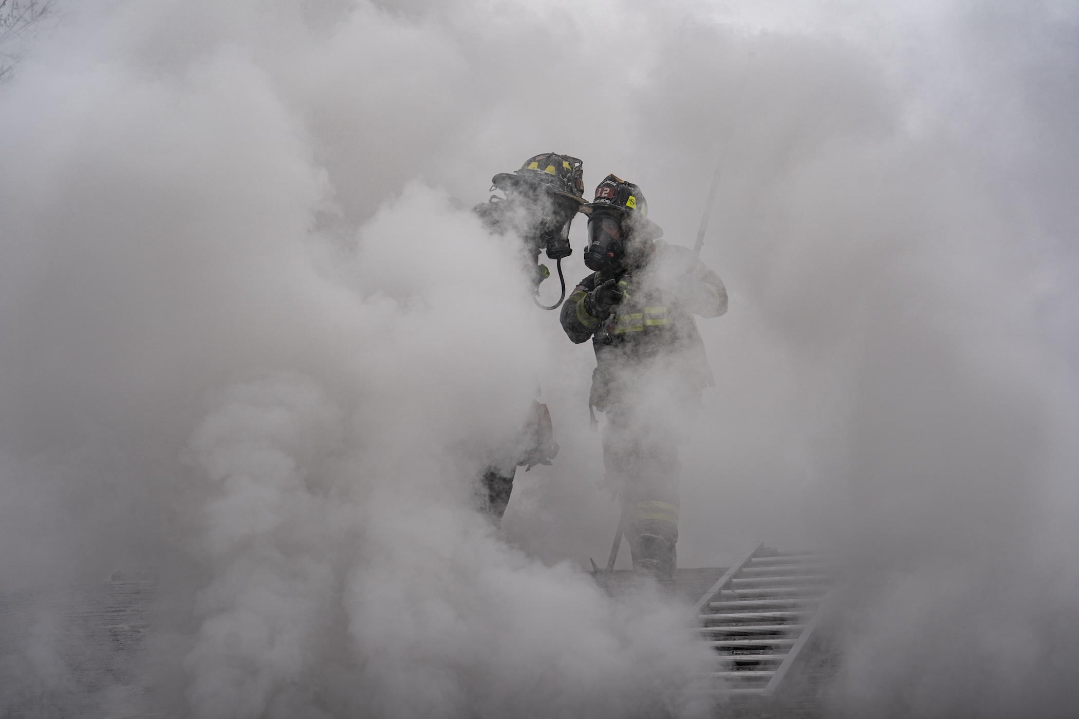 Firefighter practicing hose operations in smoke